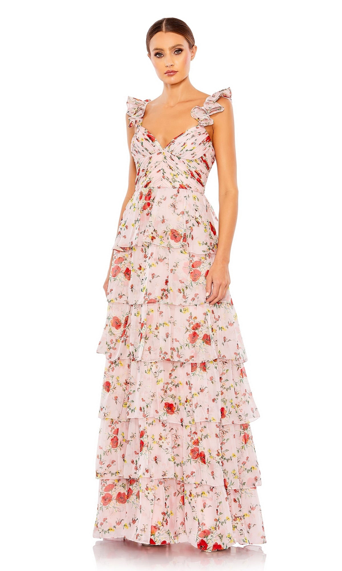 A woman wears the Long Formal Dress 55816 by Mac Duggal—a pink floral, A-line gown with ruffled shoulder straps and delicate ruffle layers—standing against a white background.